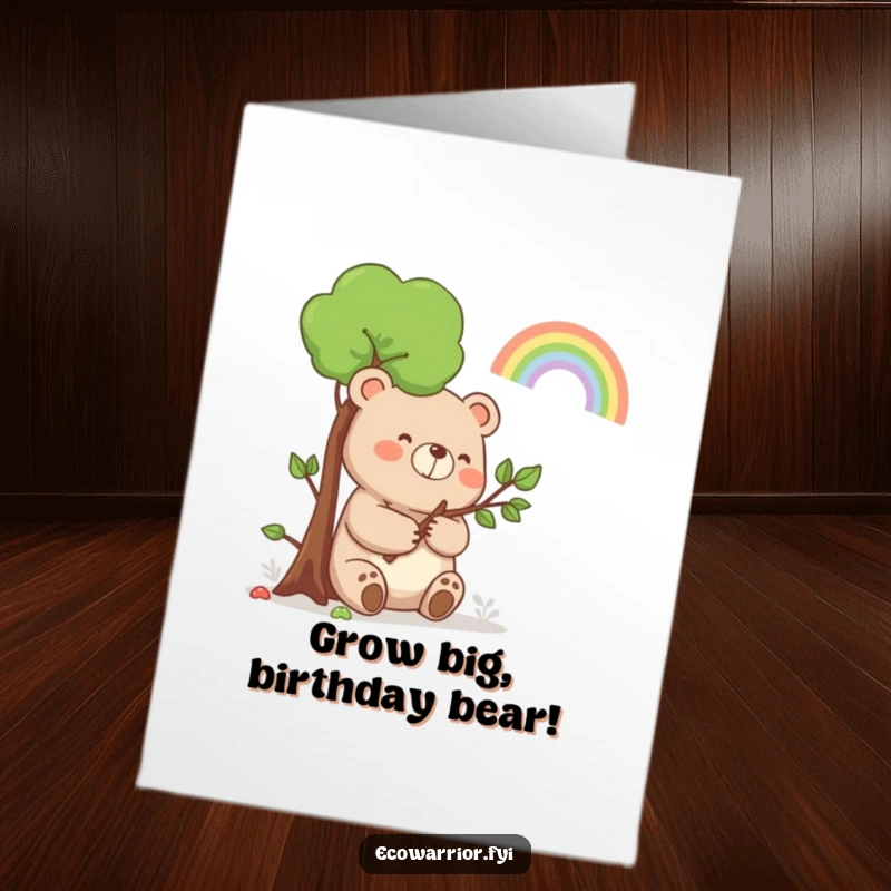 Funny free printable birthday card of a happy bear holding a small sapling and smiling towards a beautiful rainbow.